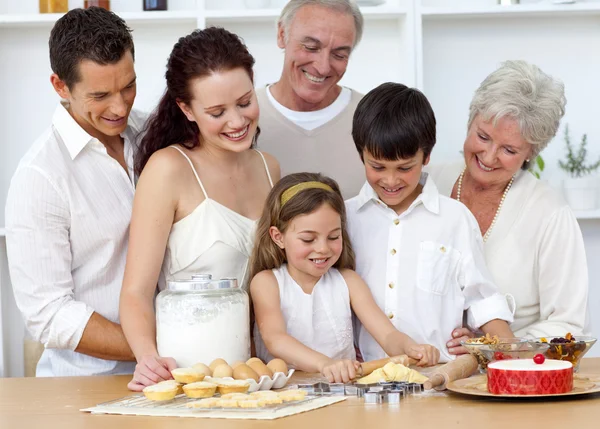 Parents and granparents looking at children baking — Stock Photo, Image