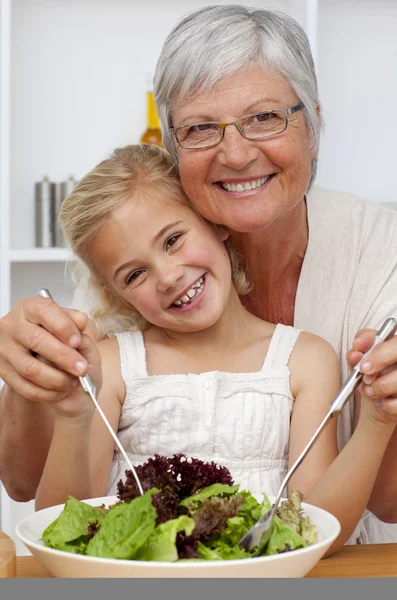 Счастливая бабушка ест салат с внучкой — стоковое фото