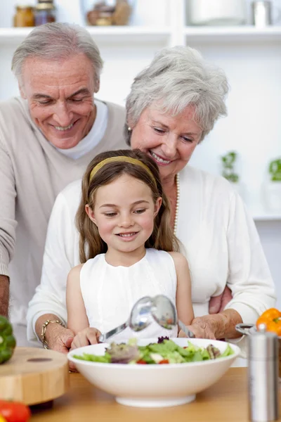 Felices abuelos comiendo una ensalada con su nieta —  Fotos de Stock