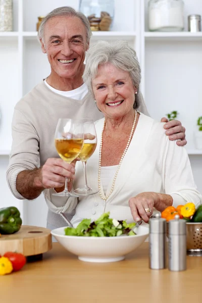 stock image Happy senior couple eating a salad in the kitchen