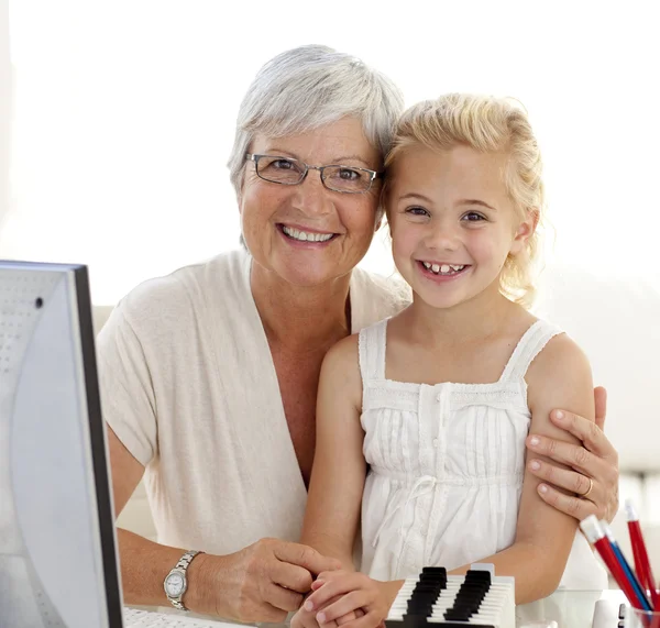 Portrait of granddaughter and grandmother using a computer — Stock Photo, Image