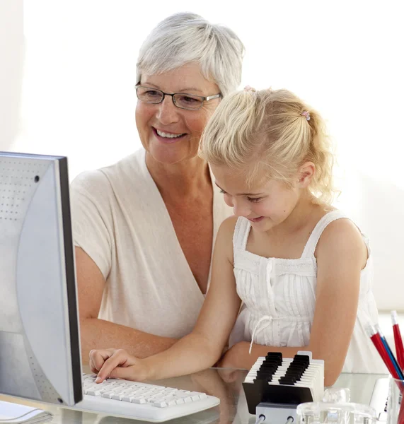 Barnbarn en dator med hennes mormor — Stockfoto