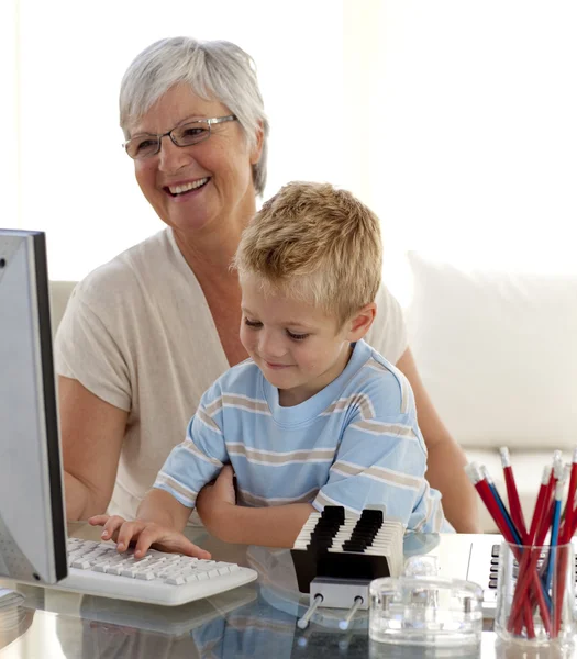 Neto usando um computador com sua avó — Fotografia de Stock