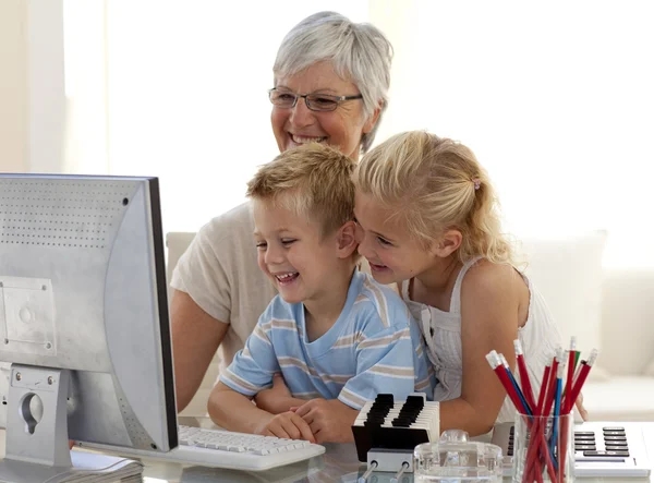 Çocuklar kendi büyükannesi ile bir bilgisayar kullanarak — Stok fotoğraf