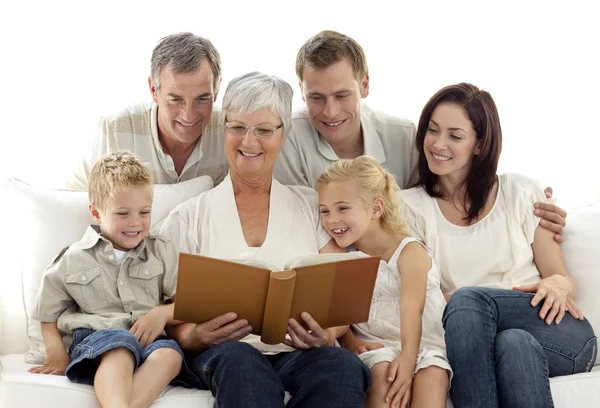 Grootmoeder lezen van een boek naar haar familie — Stockfoto