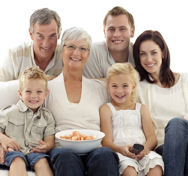Porträtt av familjen tittar på TV och äter chips — Stockfoto