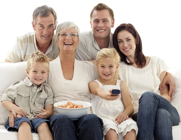 Família assistindo televisão e comendo chips em casa — Fotografia de Stock