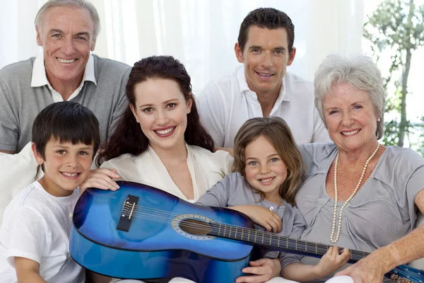 Porträtt av familj håller en gitarr i vardagsrum — Stockfoto