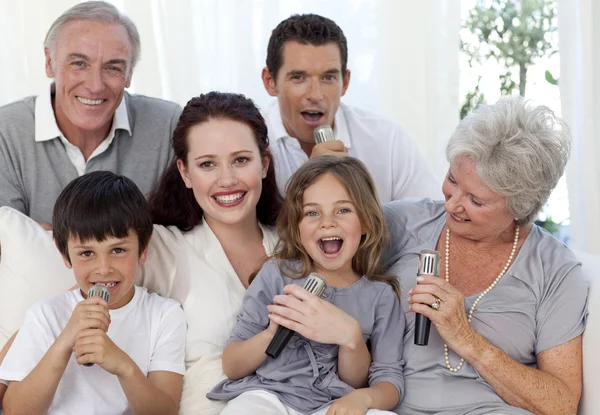 Família cantando karaoke na sala de estar — Fotografia de Stock