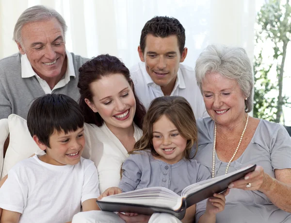 Семья читает книгу в гостиной — стоковое фото