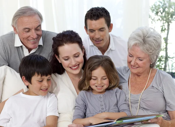 Rodzina siedzi na kanapie czytanie książki — Zdjęcie stockowe