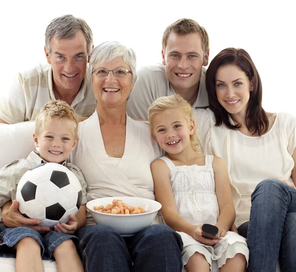 Family watching a football match at home — Stockfoto