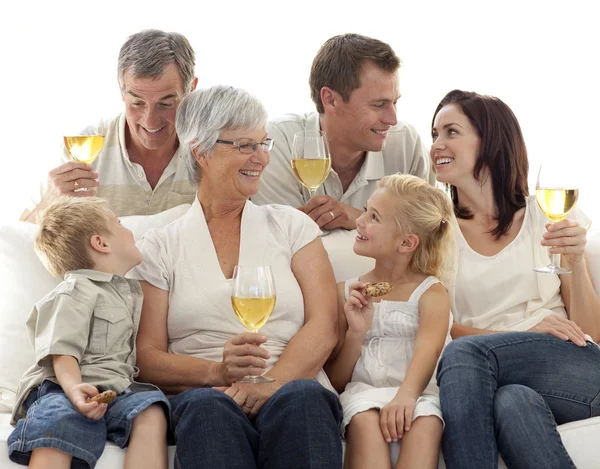 Family drinking wine and children eating biscuits — Stockfoto