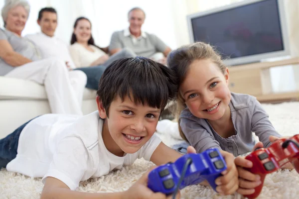 Niños jugando videojuegos y familia en el sofá —  Fotos de Stock