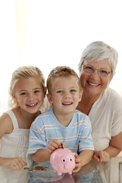 Babcia i dzieci oszczędności w skarbonka — Zdjęcie stockowe