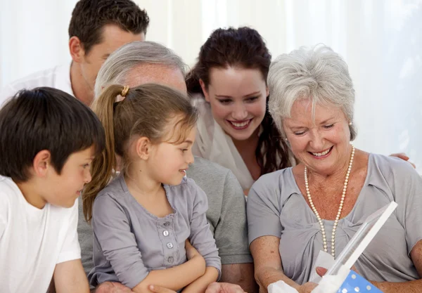Family giving a present to the grandmother — Stock Photo, Image