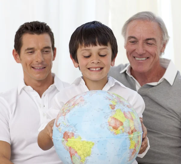 Fils, père et grand-père regardant un globe terrestre — Photo