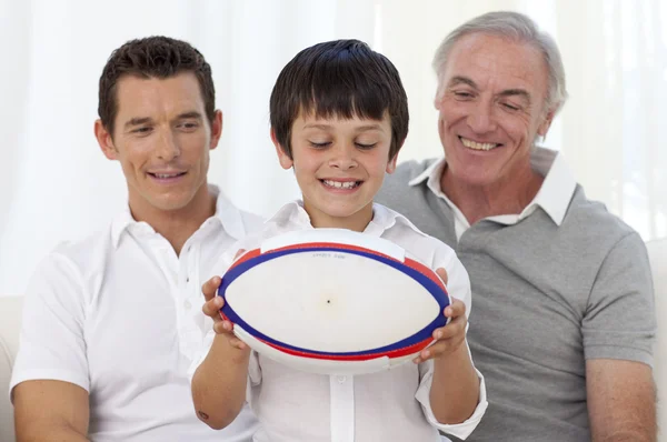 Hijo sosteniendo una pelota de rugby con su padre y su abuelo —  Fotos de Stock