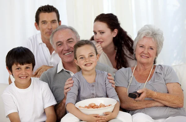 Семья ест чипсы и смотрит телевизор — стоковое фото