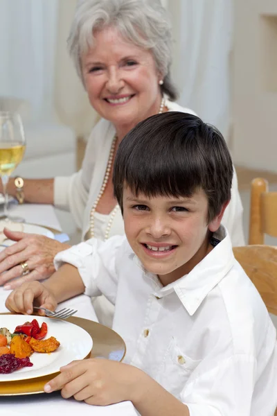 微笑的男孩和他的家人一起吃晚餐 — 图库照片