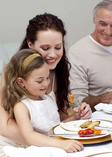 Madre e figlia mangiare con la loro famiglia — Foto Stock
