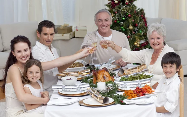 Семья пьет тост за рождественским ужином — стоковое фото