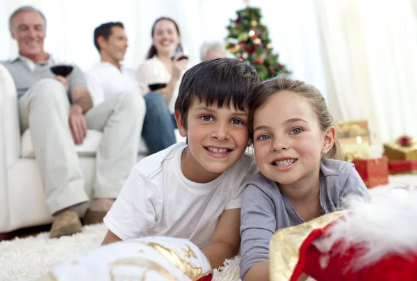 Children lying on floor with their family in Christmas — Stock Photo, Image
