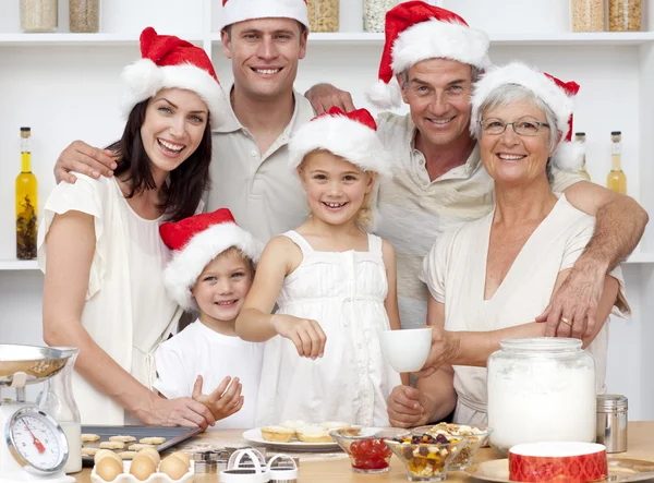 Children baking Christmas cakes in the kitchen with their family — Stock Photo, Image