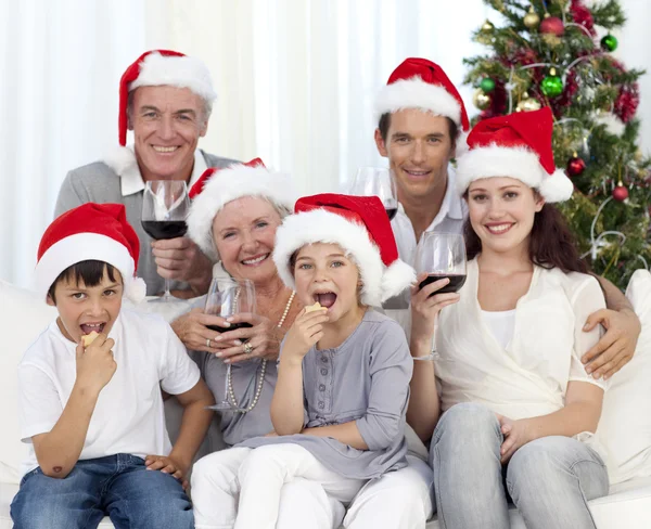 Сім'я п'є вино і їсть цукерки на Різдво — стокове фото