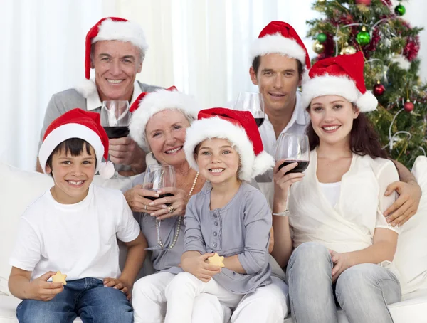 Famille célébrant Noël avec du vin et des bonbons — Photo
