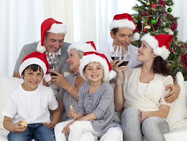 Rodina slaví Vánoce s vínem a sladkosti doma — Stock fotografie