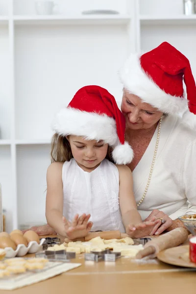 Großmutter und kleines Mädchen backen Weihnachtskuchen — Stockfoto