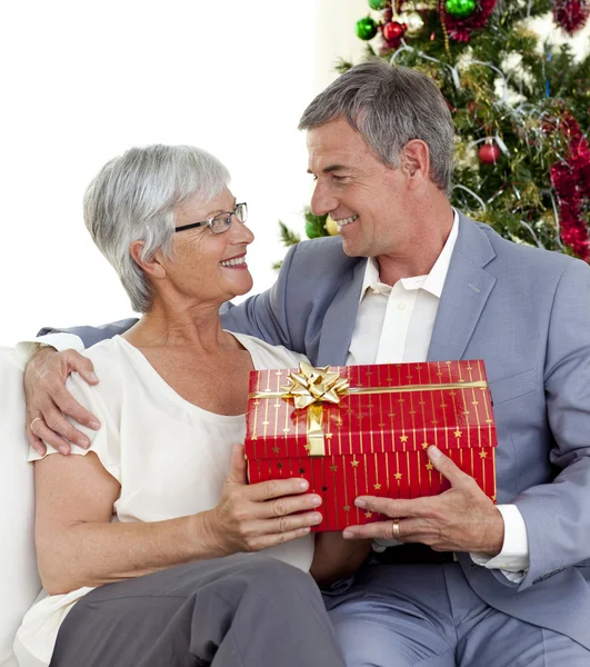 Старший мужчина дарит подарок жене на Рождество — стоковое фото