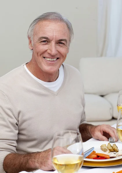 Старший мужчина ест индейку на рождественском ужине — стоковое фото