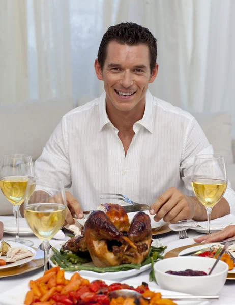 Smiling man eating turkey in Christmas dinner — Stock Photo, Image