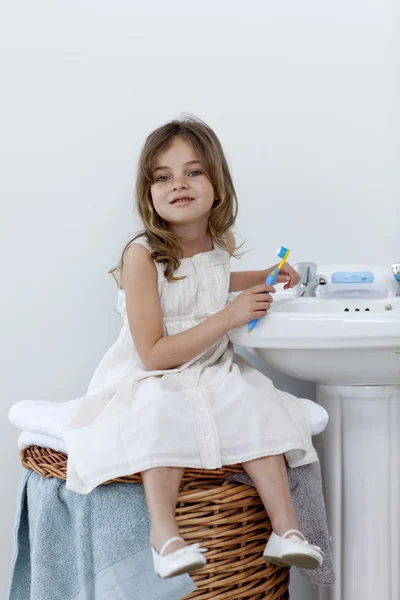 Liten flicka sitter i badrum städning hennes tänder — Stockfoto