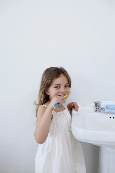 Little girl cleaning her teeth in bathroom with copy-space — Stock Photo, Image
