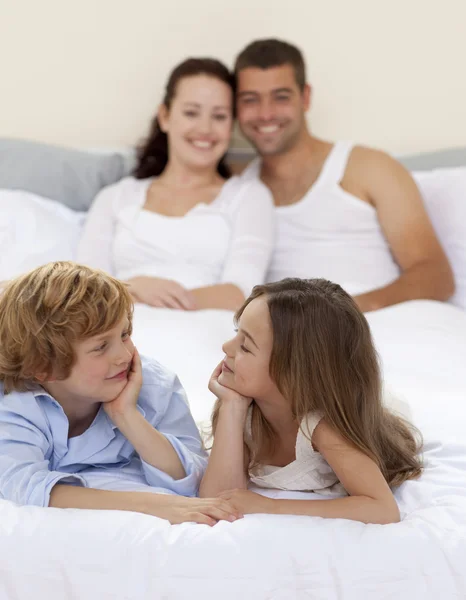 Bruder und Schwester im Bett mit ihren Eltern — Stockfoto