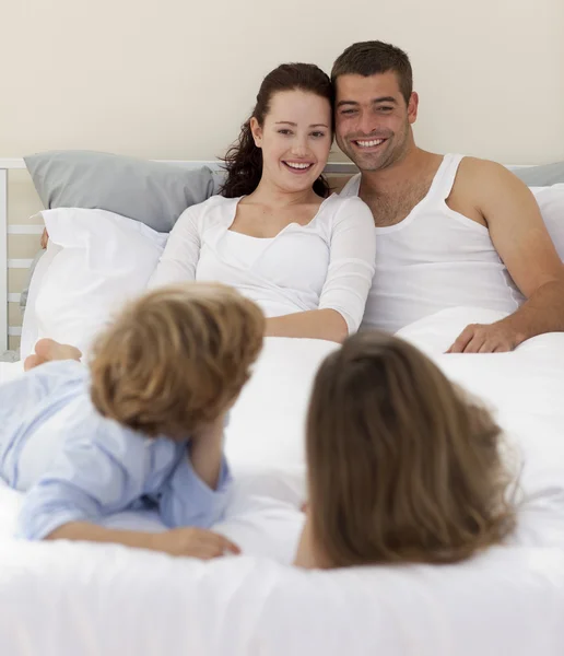 Bracia i rodzice leżąc w łóżku — Zdjęcie stockowe