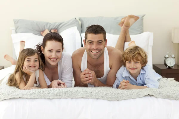 Pijama ile yatakta yatan aile — Stok fotoğraf