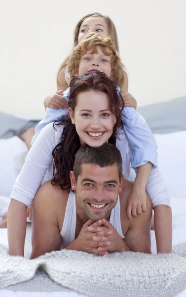 Батько, мати, син і дочка в горі в ліжку — стокове фото