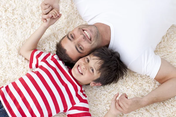 Father and son on floor with heads together — Stock Photo, Image