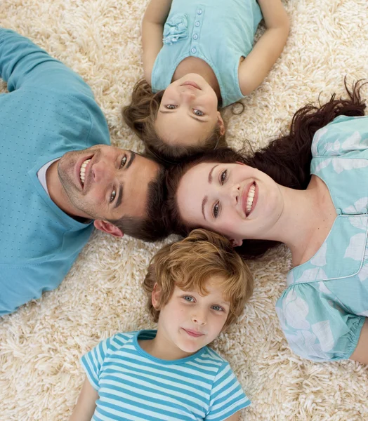 Família feliz no chão com cabeças juntas — Fotografia de Stock
