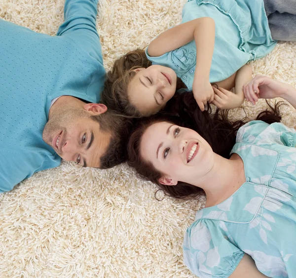 Pais e filha no chão com as cabeças juntas — Fotografia de Stock
