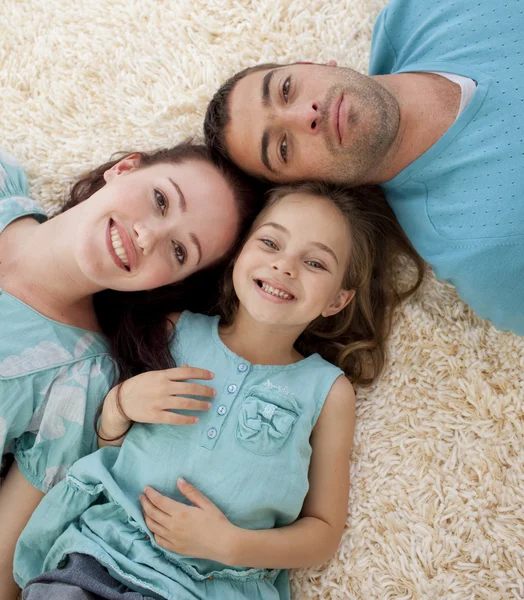 Portrait of parents and daughter on floor with heads together — Stock Photo, Image