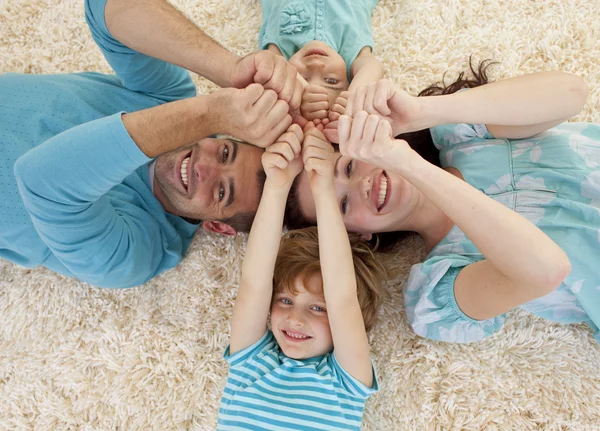 Happy family on floor with heads and hands together — Stock Photo, Image