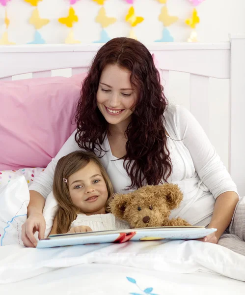 母亲和女儿在床上阅读 — 图库照片