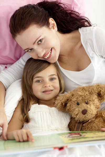 Beautiful mother and daughter reading a book — Stock Photo, Image