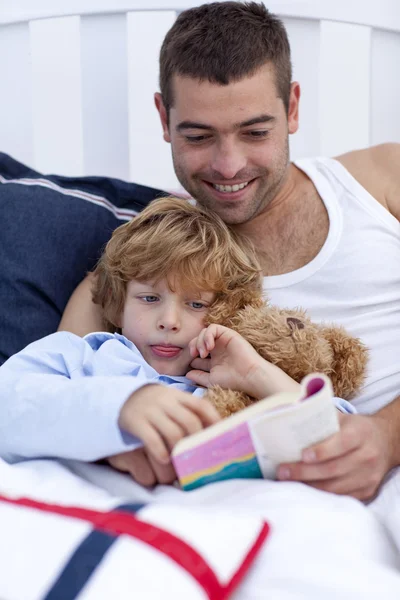 Niño leyendo con su padre un libro —  Fotos de Stock
