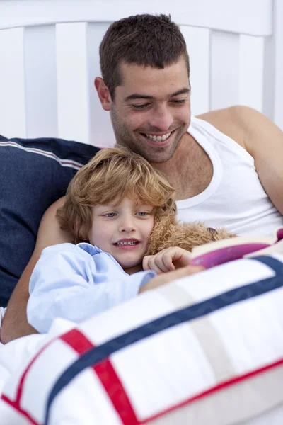 Papa et enfant lisant un livre au lit — Photo